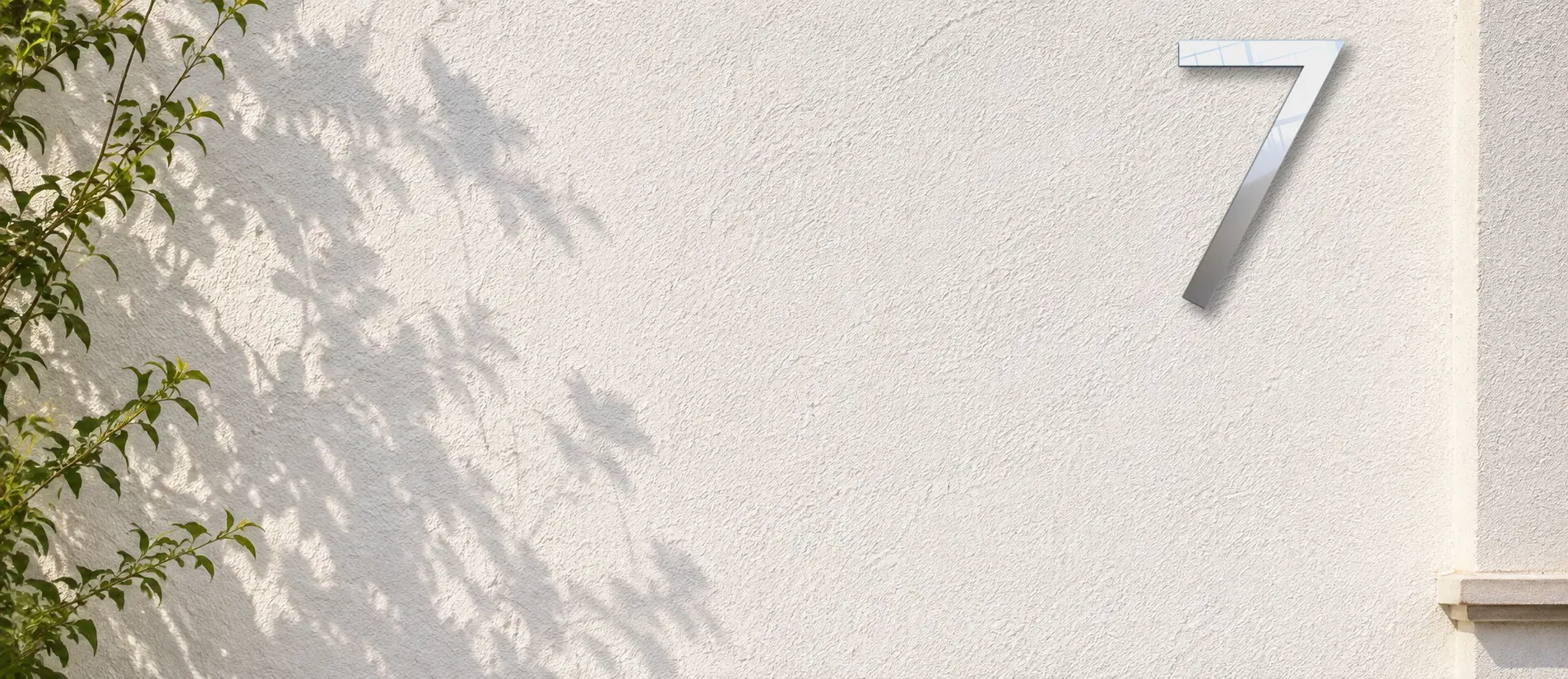 Mur en crépi blanc au soleil, surface plane à hauteur d’œil