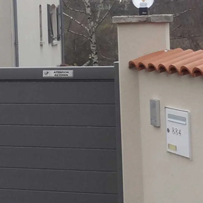 Mini plaque attention au chien en aluminium brossé, format bandeau, fixée sur un portail gris près d’une boîte aux lettres